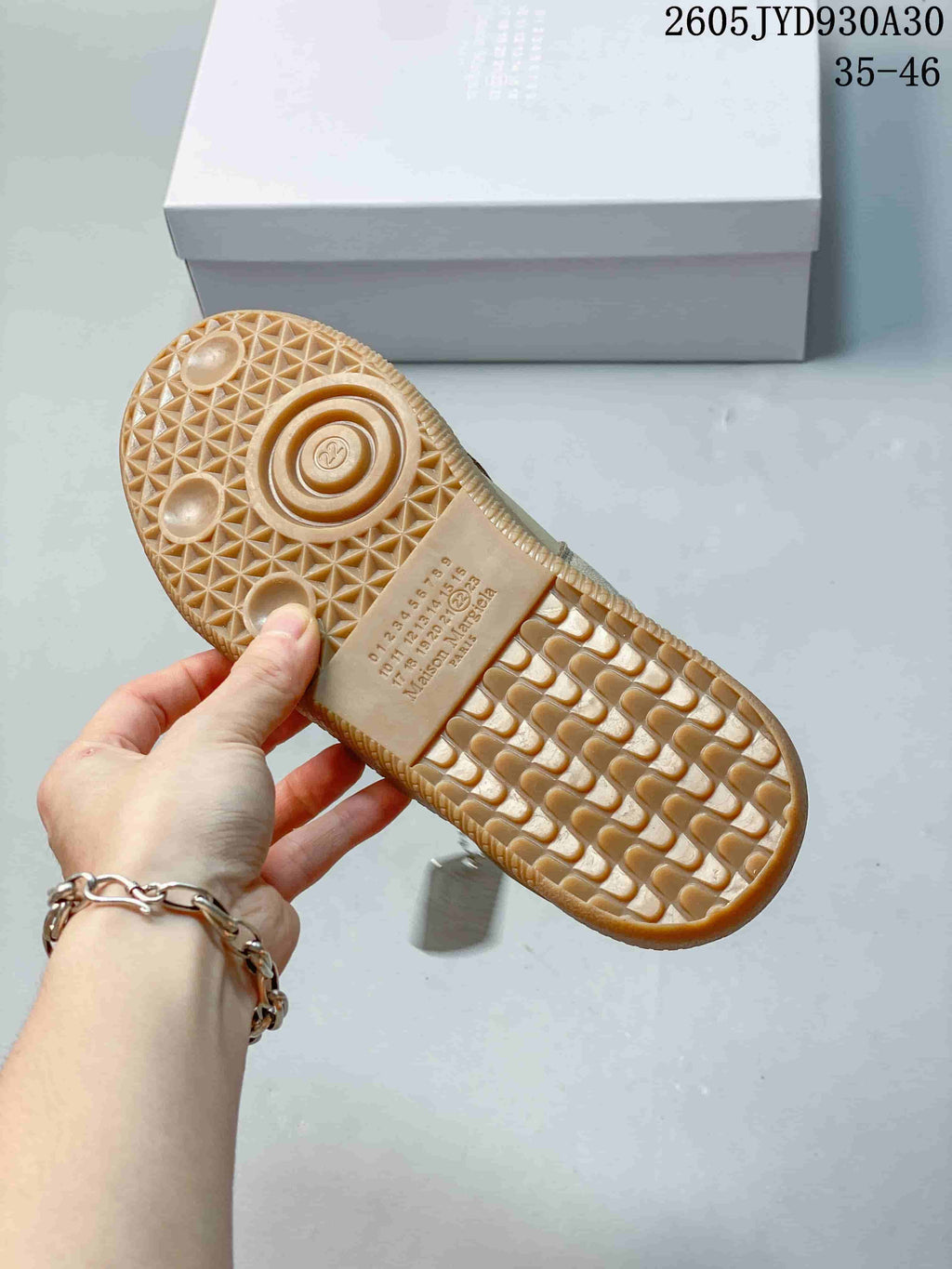 Close view of the gum-colored sneaker outsole with a patterned tread.