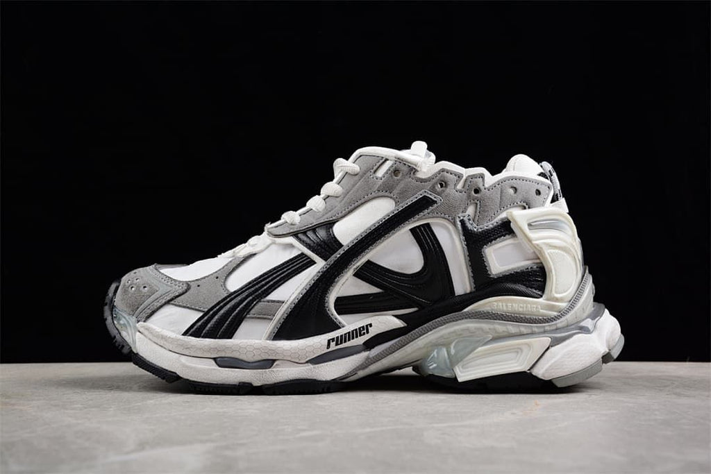 Side view of grey, white, and black Balenciaga Runner sneakers