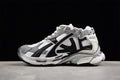 Side view of grey, white, and black Balenciaga Runner sneakers