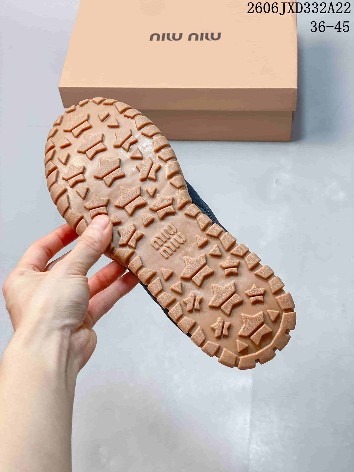Close-up of the tan-colored outsole tread and branded shoebox.
