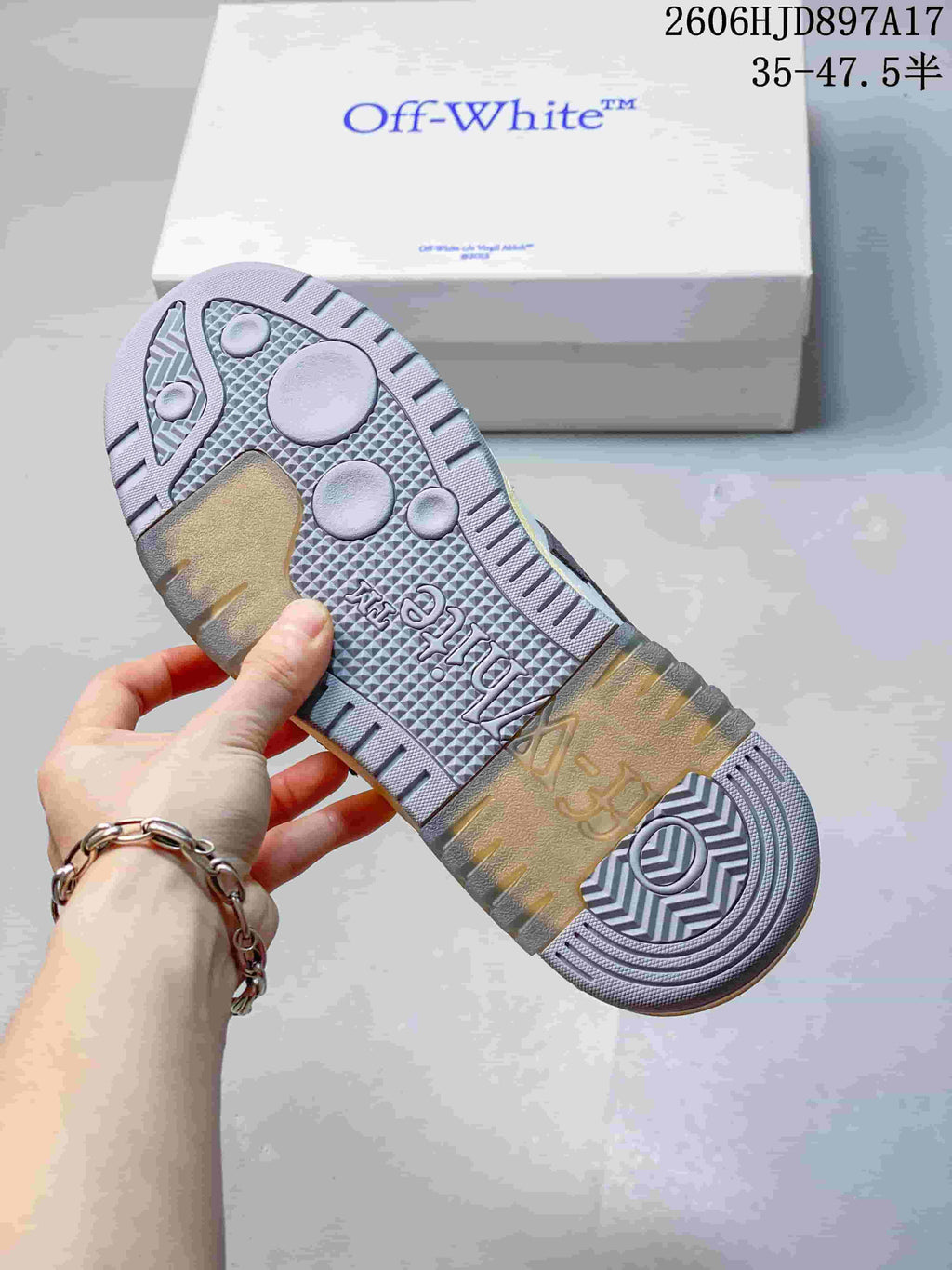 Close-up of the sneaker outsole, showing its textured grey tread and pale yellow sections
