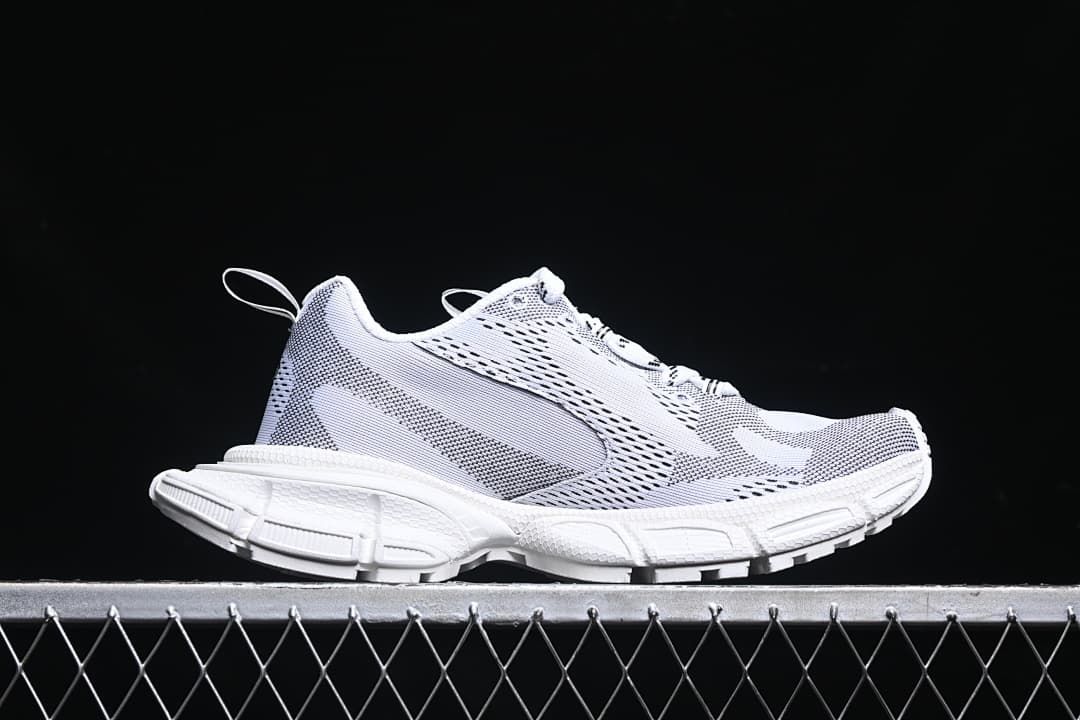 Side profile of the white sneaker with a sculpted chunky sole.