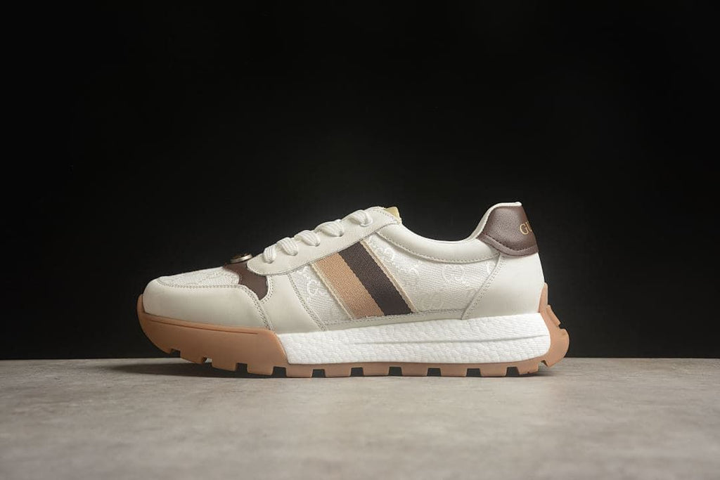 Side view of the sneaker with ivory upper, brown accents, and gum-colored outsole