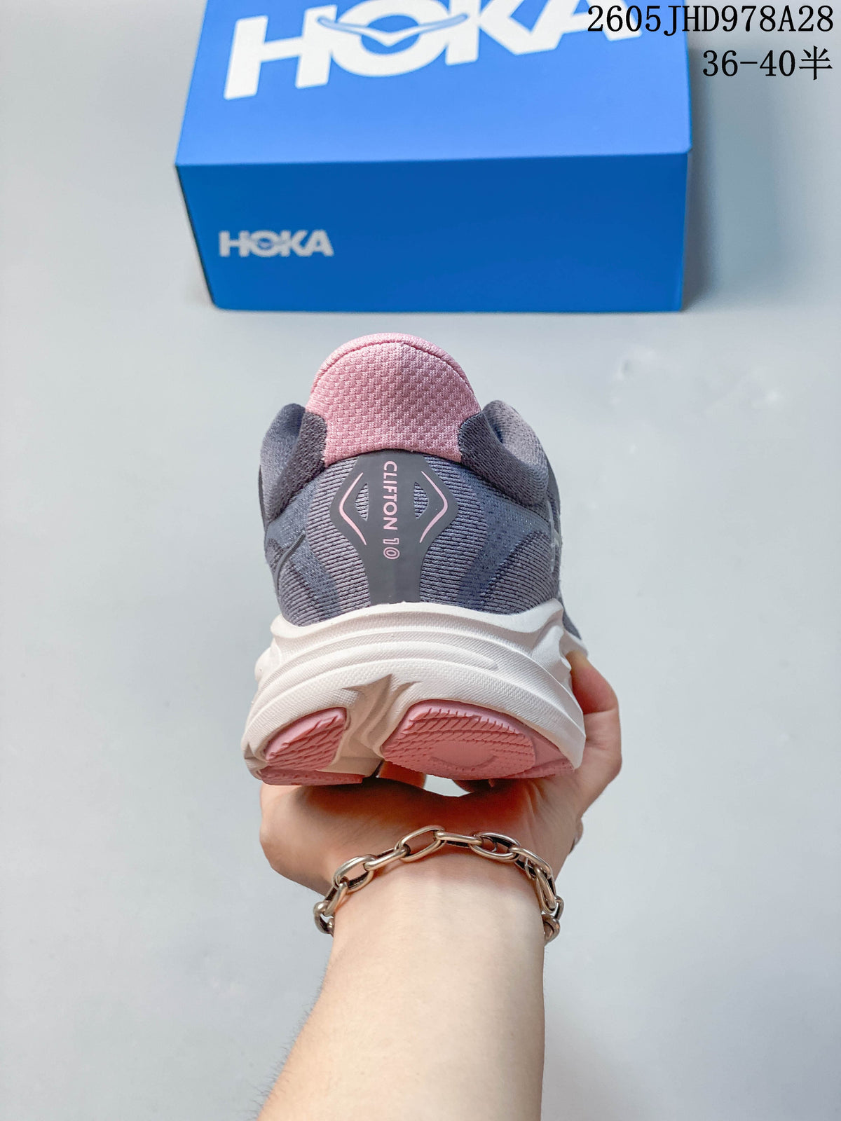 Rear view of a gray HOKA Clifton 10 shoe with pink heel details