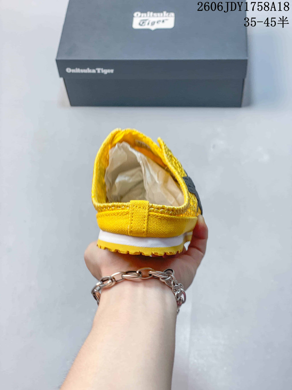 Rear view of the yellow slip-on sneaker showing its open-back design