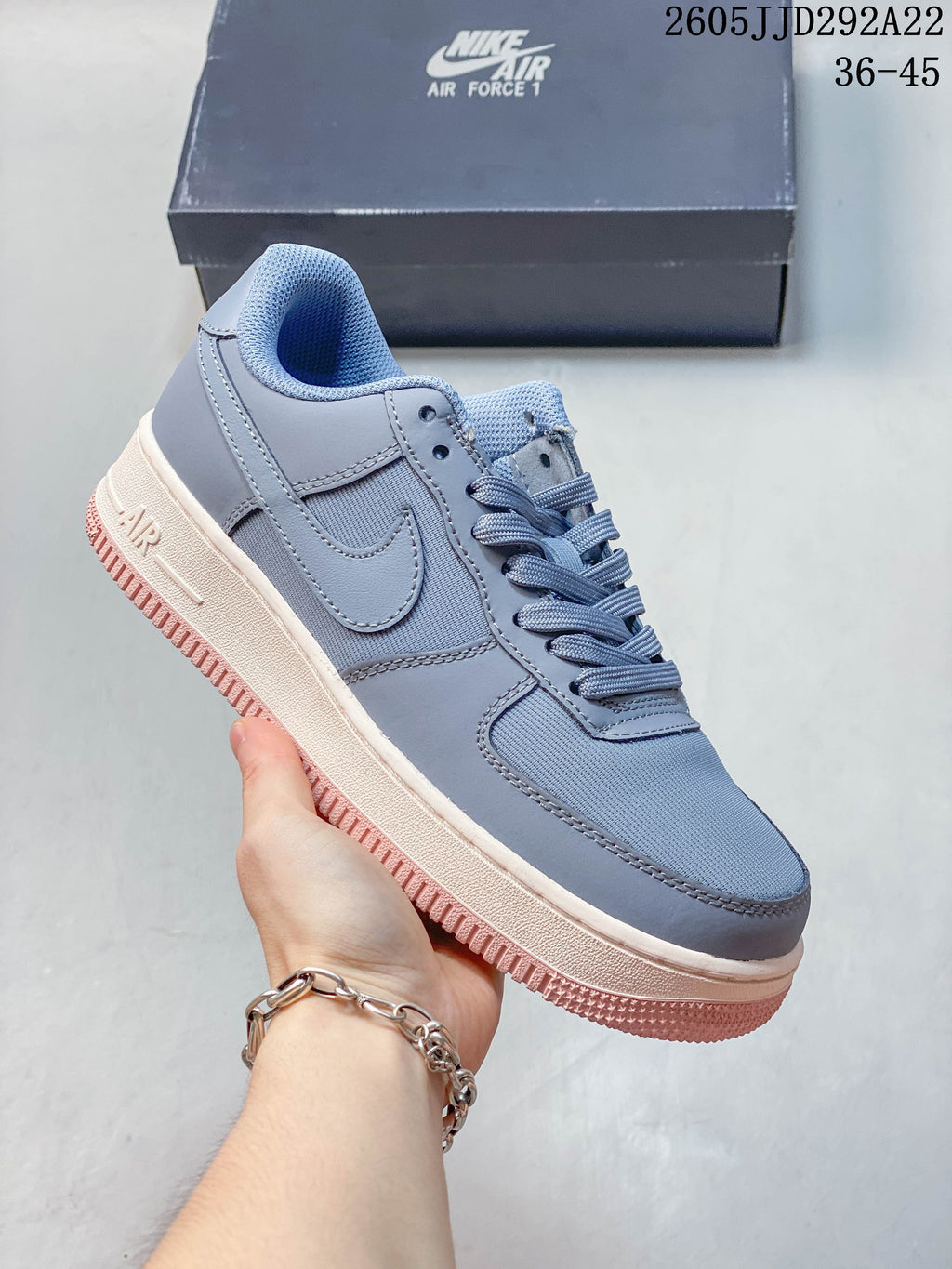 Blue-gray low-top sneaker with a pale midsole and pink outsole