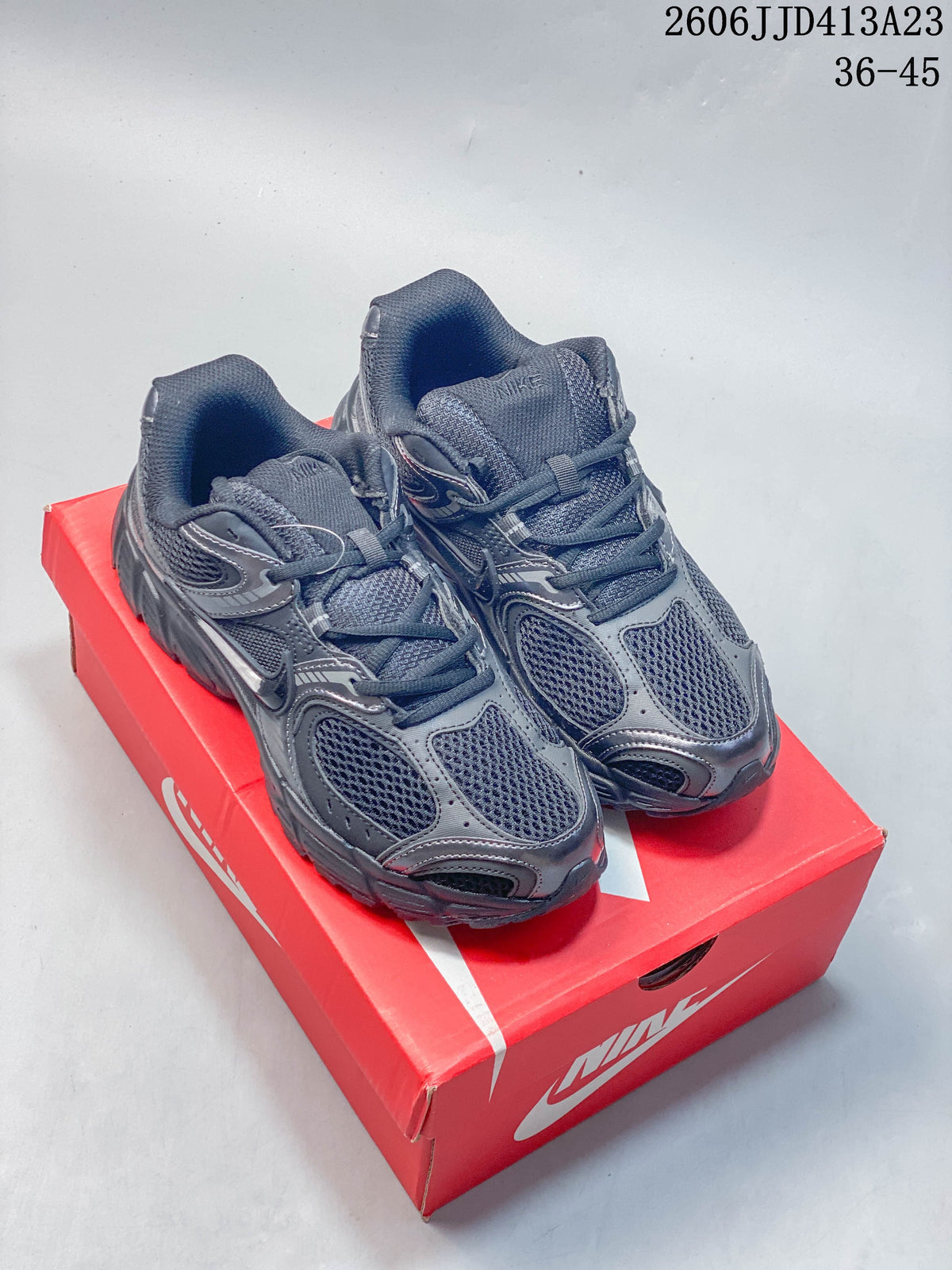 Pair of dark charcoal Nike Air Zoom Winflo 12 shoes displayed on a red Nike box