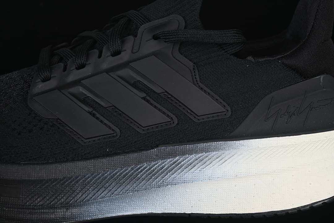 Close-up of the three-stripe side detail, knit-look upper, and sculpted midsole