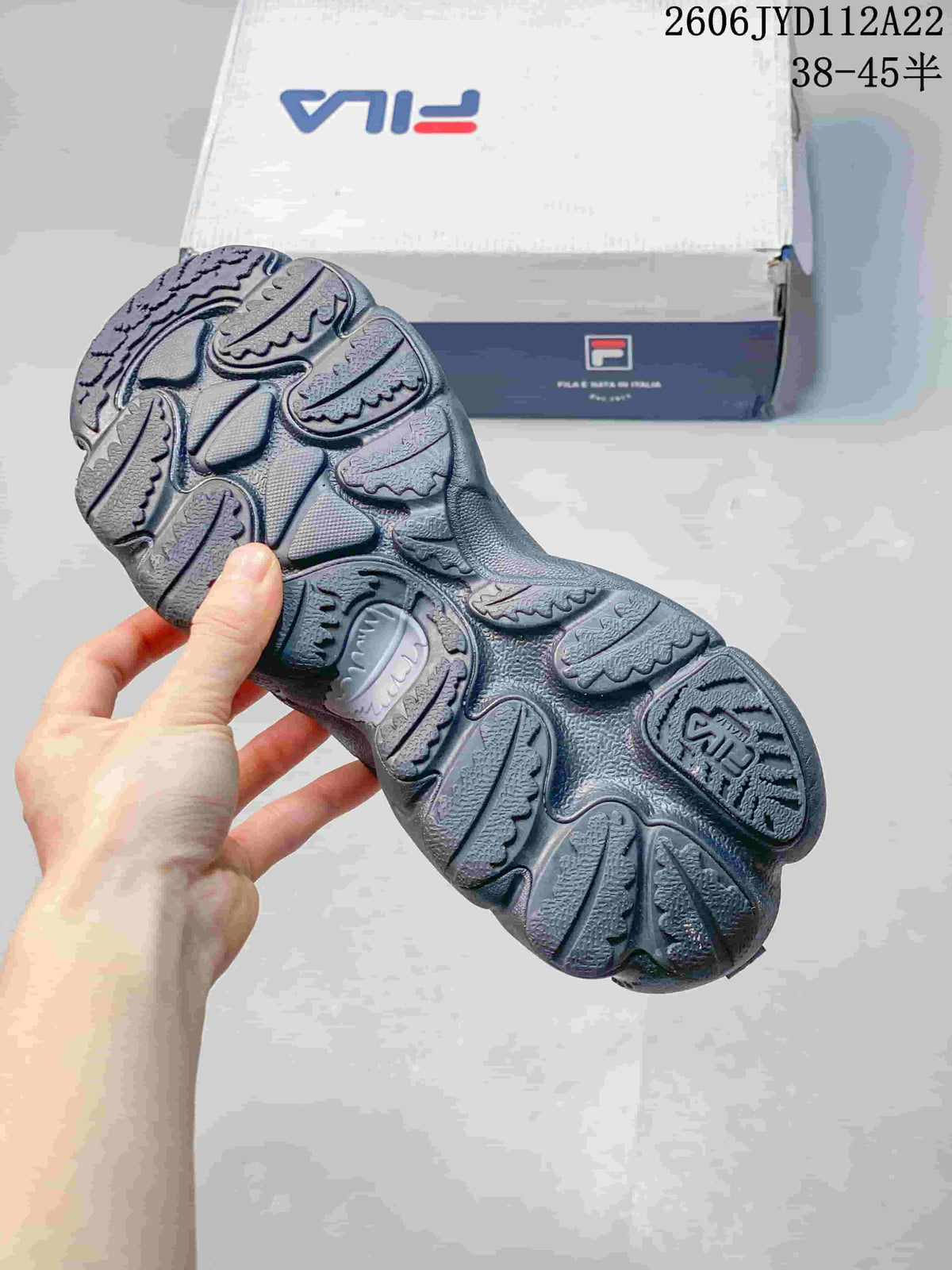 Close view of the patterned outsole of a gray FILA sneaker