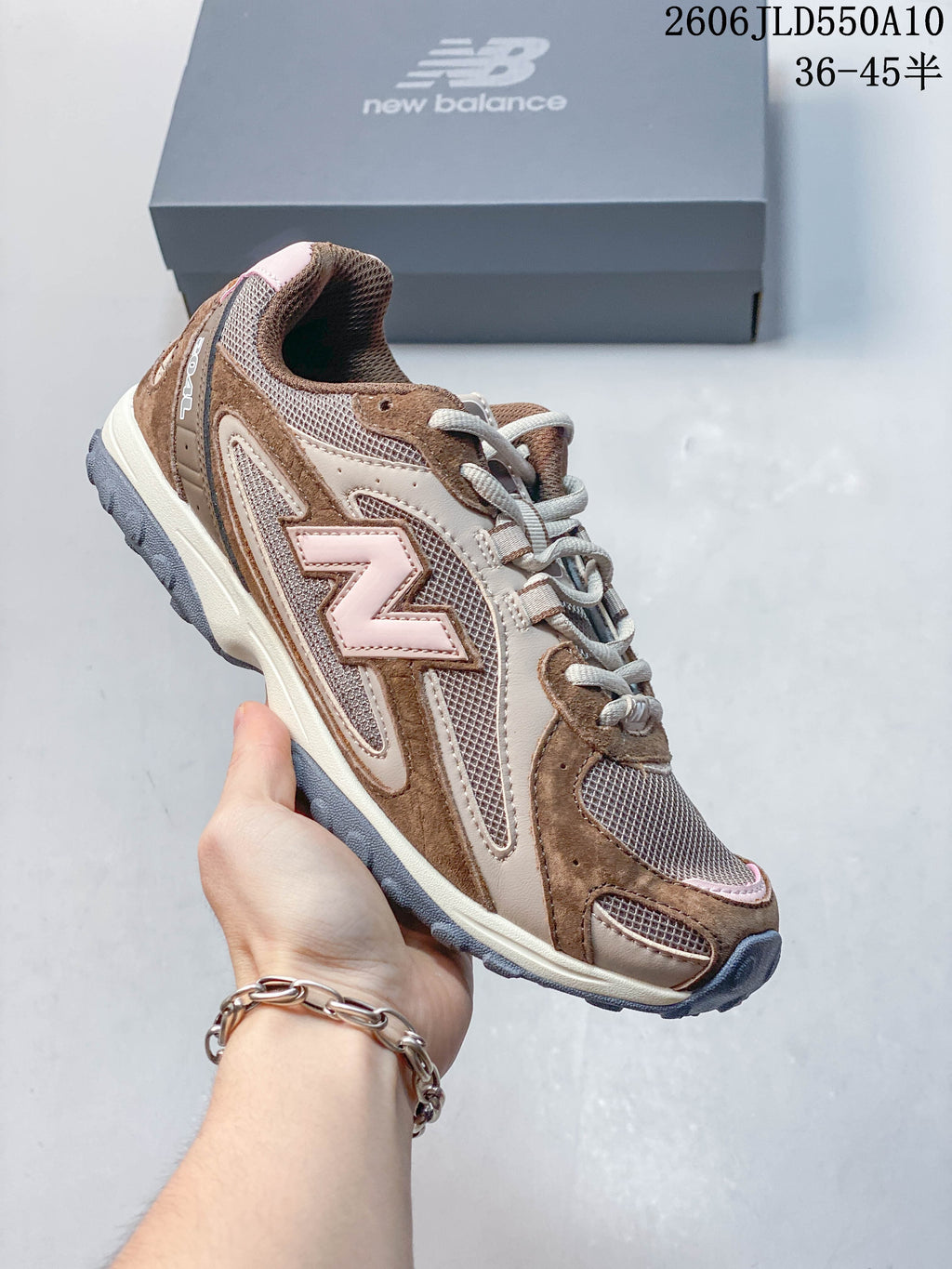 Side profile of a brown and beige New Balance 204L sneaker with pale pink accents