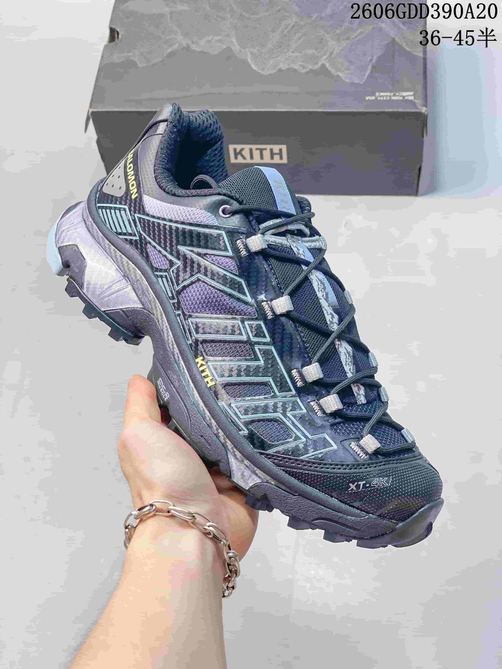 Angled view of the Salomon XT-4K shoe showing its dark blue-gray upper, patterned overlays and lugged sole.
