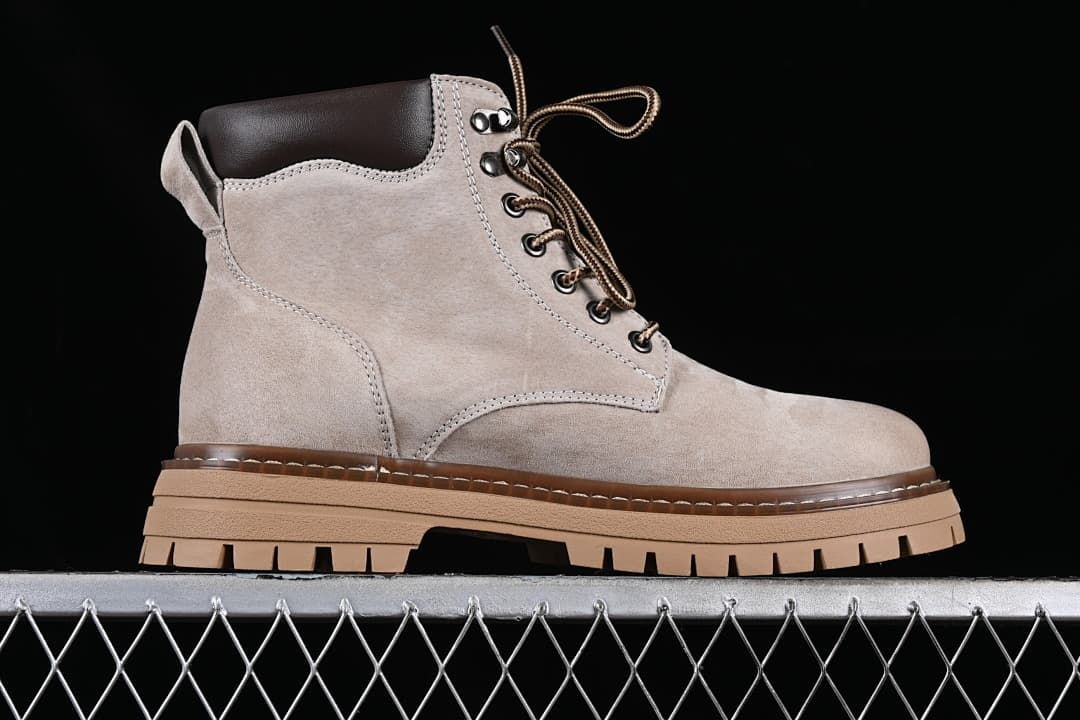 Side profile of a beige-grey lace-up boot with a dark brown collar and tan lugged sole