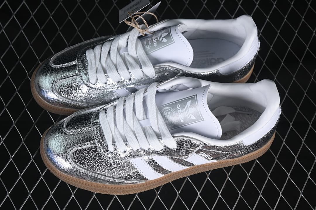 Pair of silver-toned Samba OG sneakers with white laces and gum-colored soles