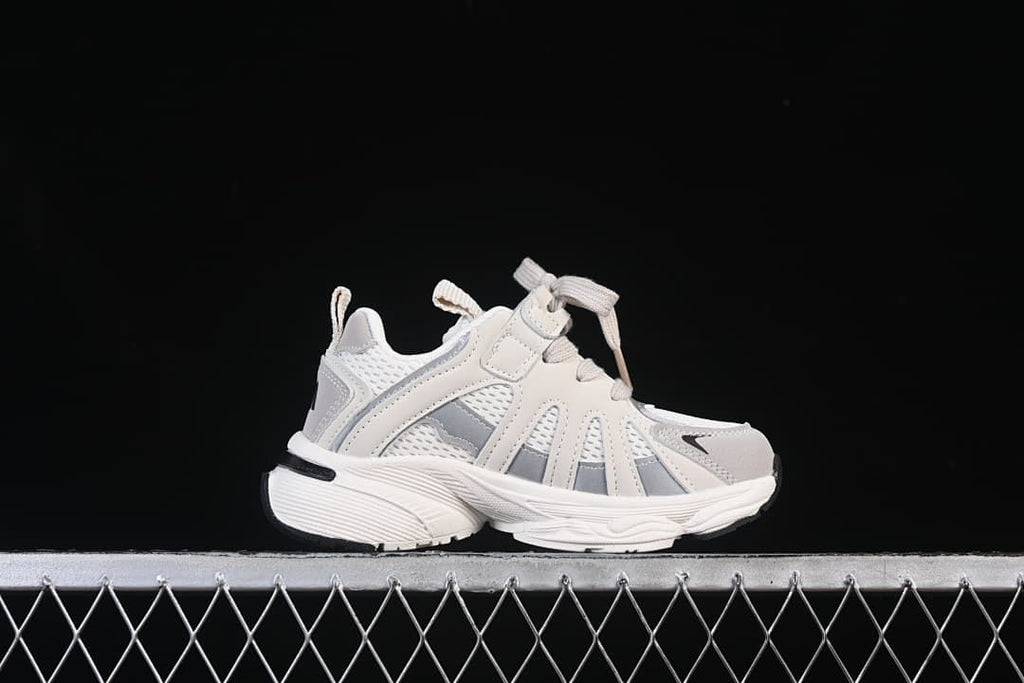 Side profile of a white and grey kids’ sneaker