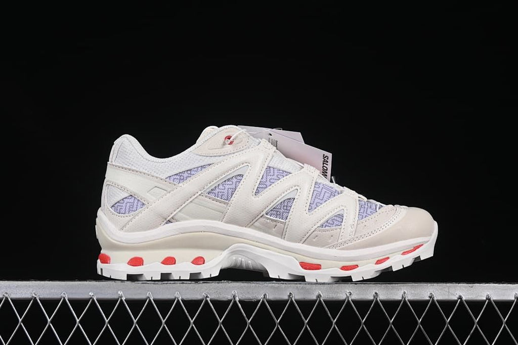 Side profile of the shoe with layered supports and red outsole details.
