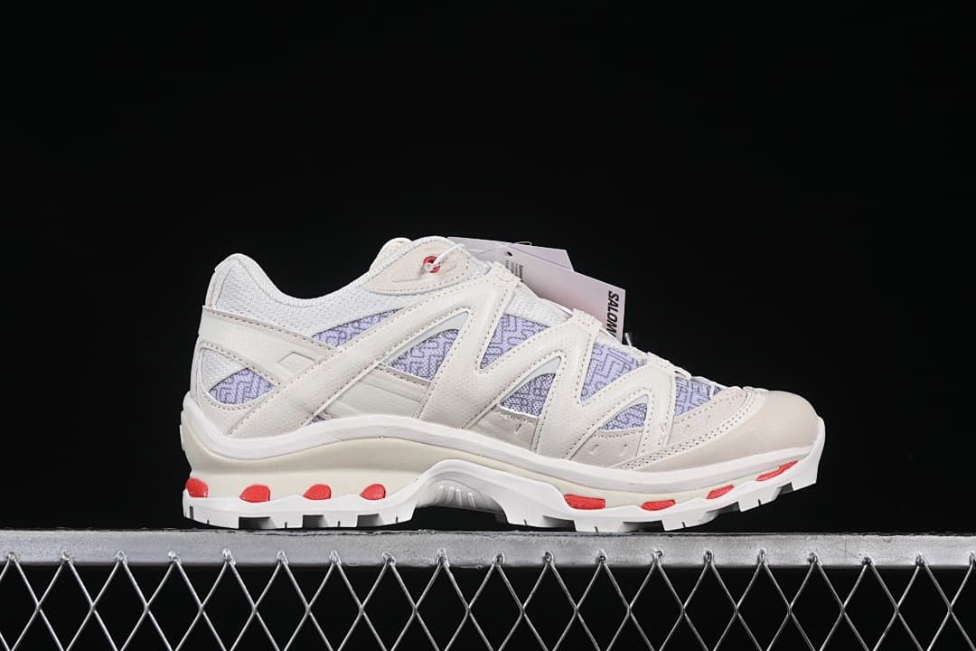 Side profile of the shoe with layered supports and red outsole details.