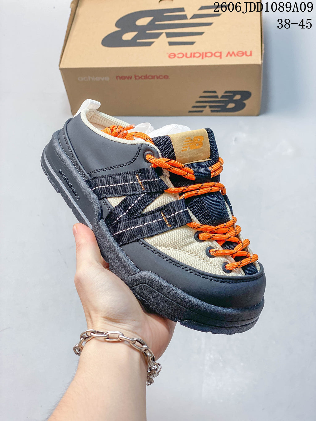 Close-up of a navy and cream New Balance Terrace Mule with orange laces.
