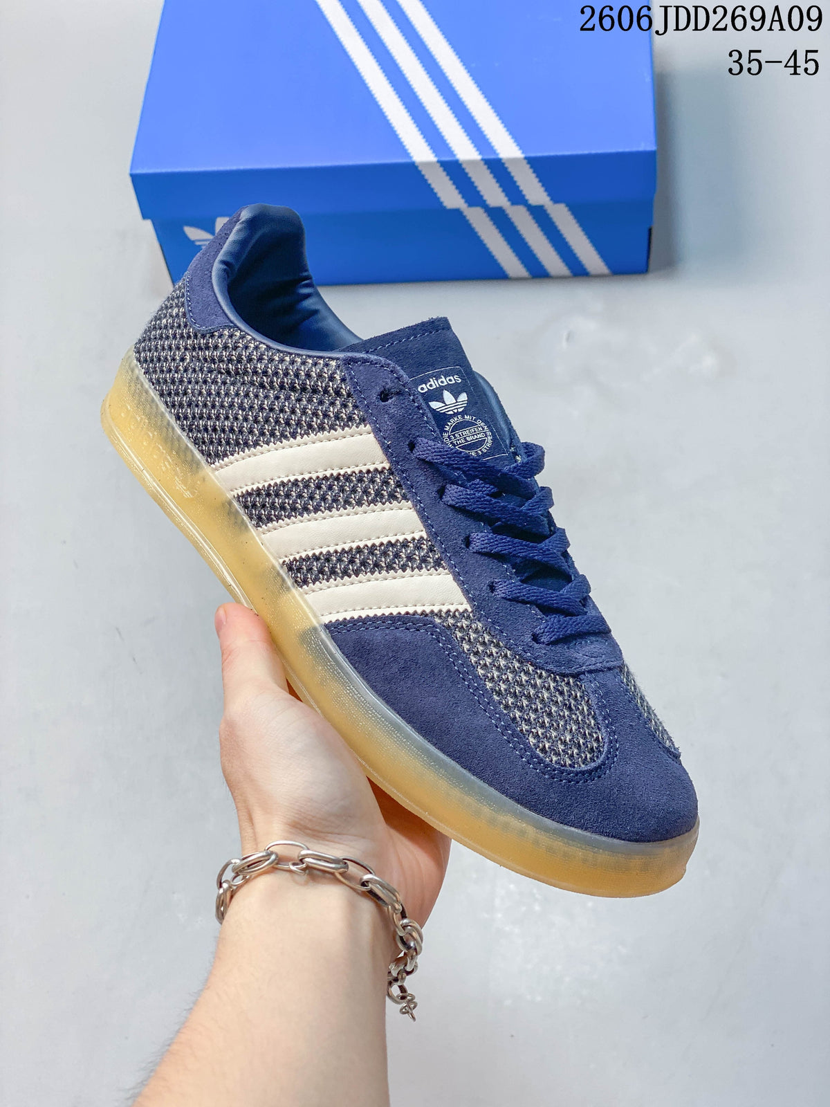 Side view of a navy adidas Gazelle Indoor sneaker with light stripes and a gum-colored outsole