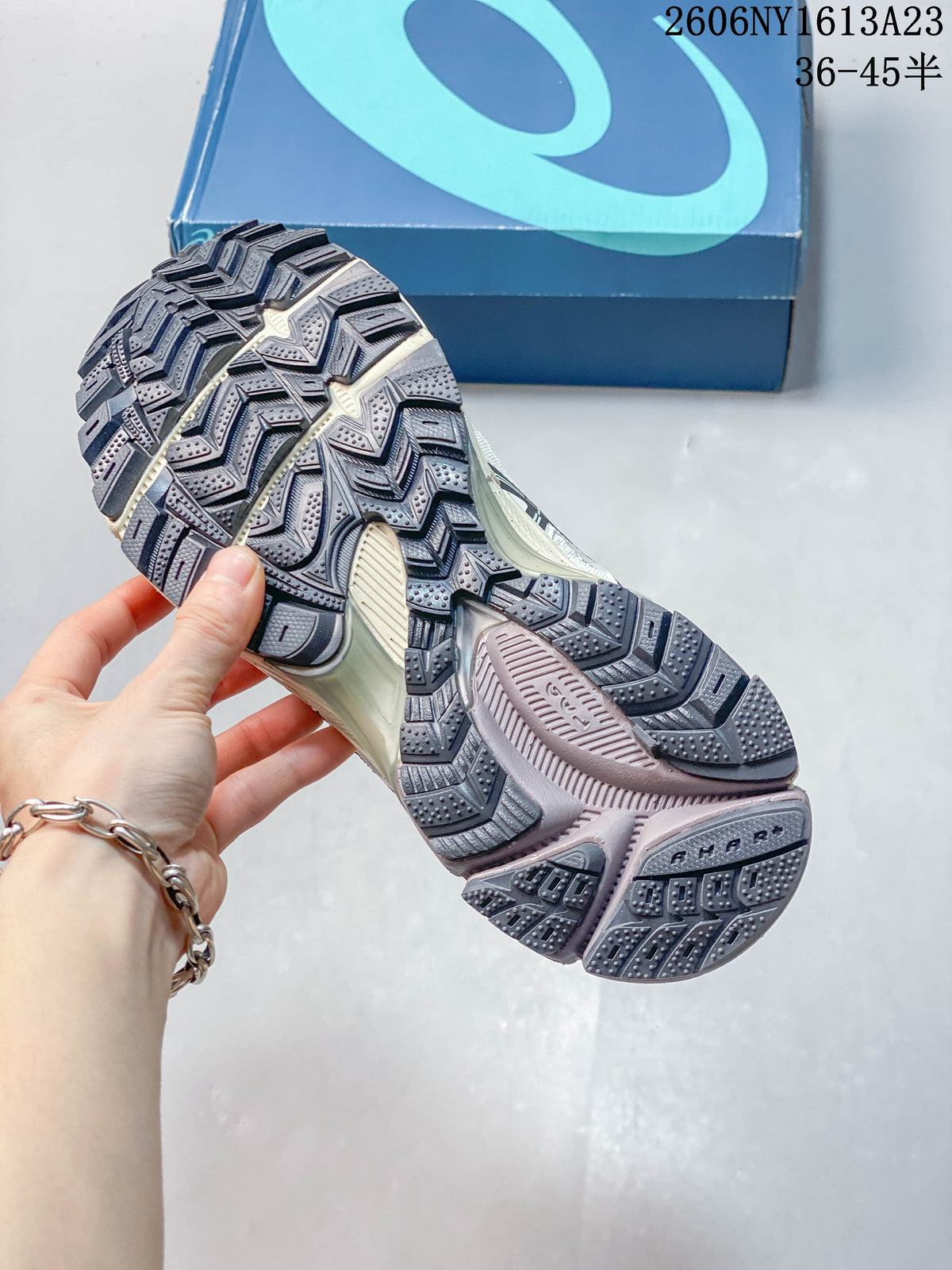 Close-up of the patterned tread on a cream and navy ASICS Gel-Kahana 8 shoe