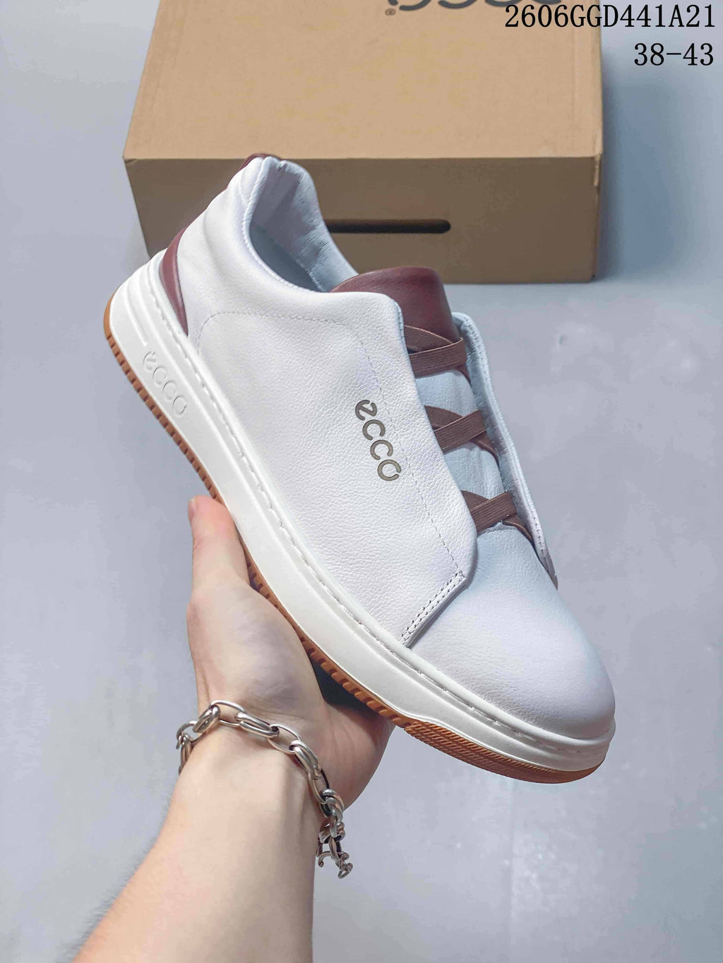 Side view of a white ECCO slip-on sneaker with brown elastic straps and a white sole.