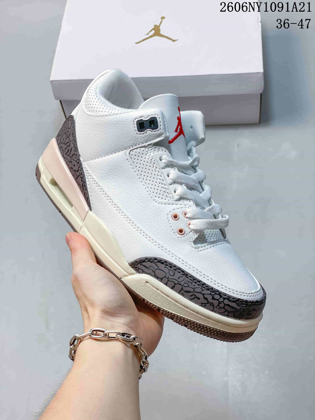 Angled side view of the white sneaker with dark patterned overlays