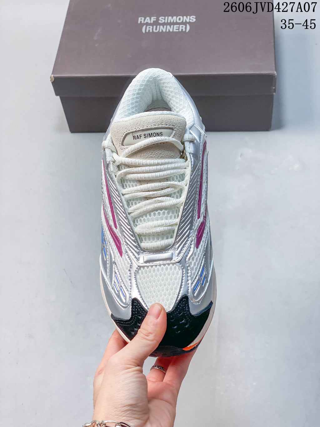 Top view of a white mesh sneaker with silver overlays, magenta details, dark toe panels, and white laces; image overlay shows 35–45.