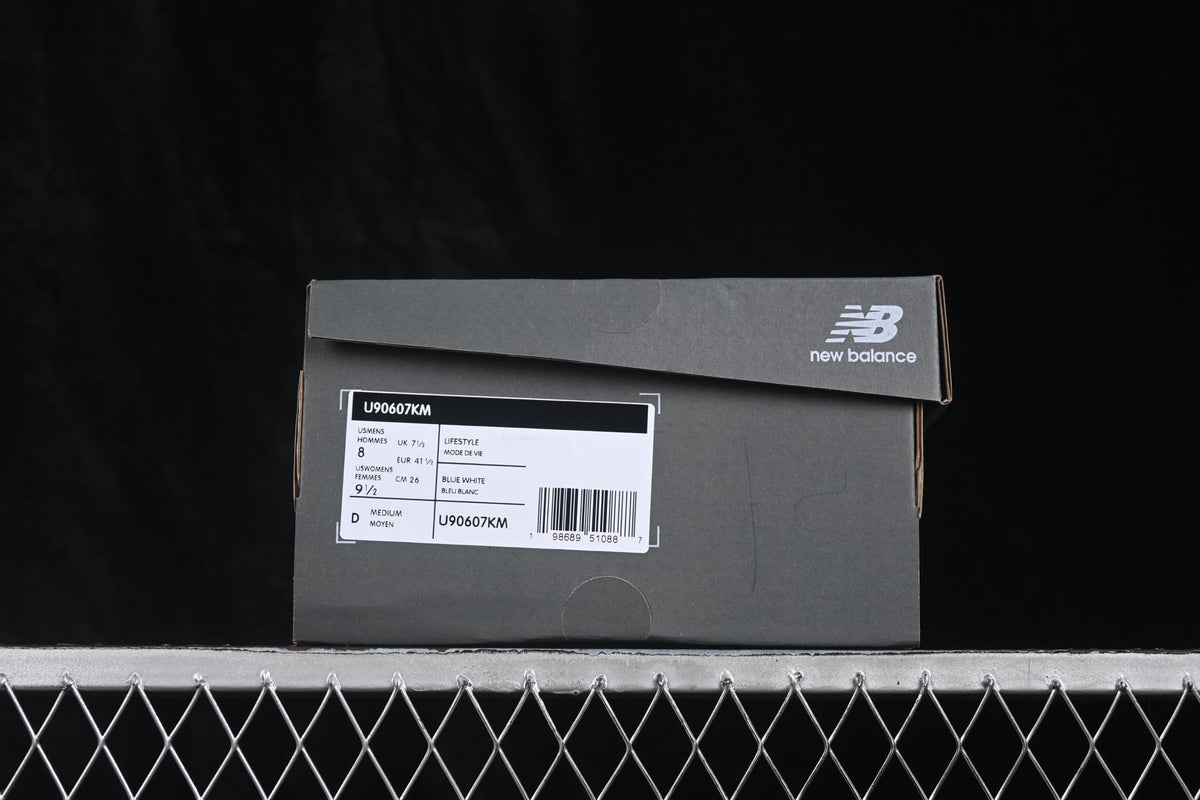 New Balance shoe box showing style code U90607KM, Blue White color, and a sample size label.