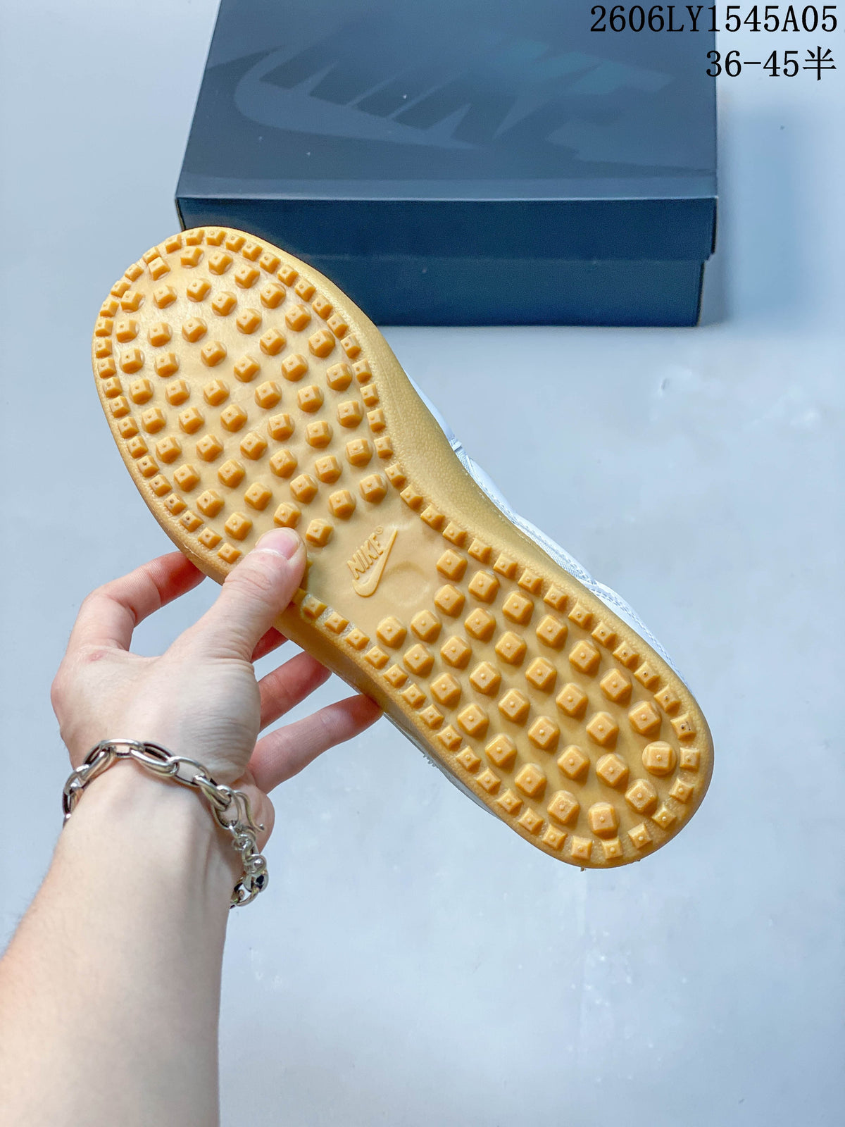 Close-up of the gum-colored outsole and raised tread on a white Nike Field General sneaker.
