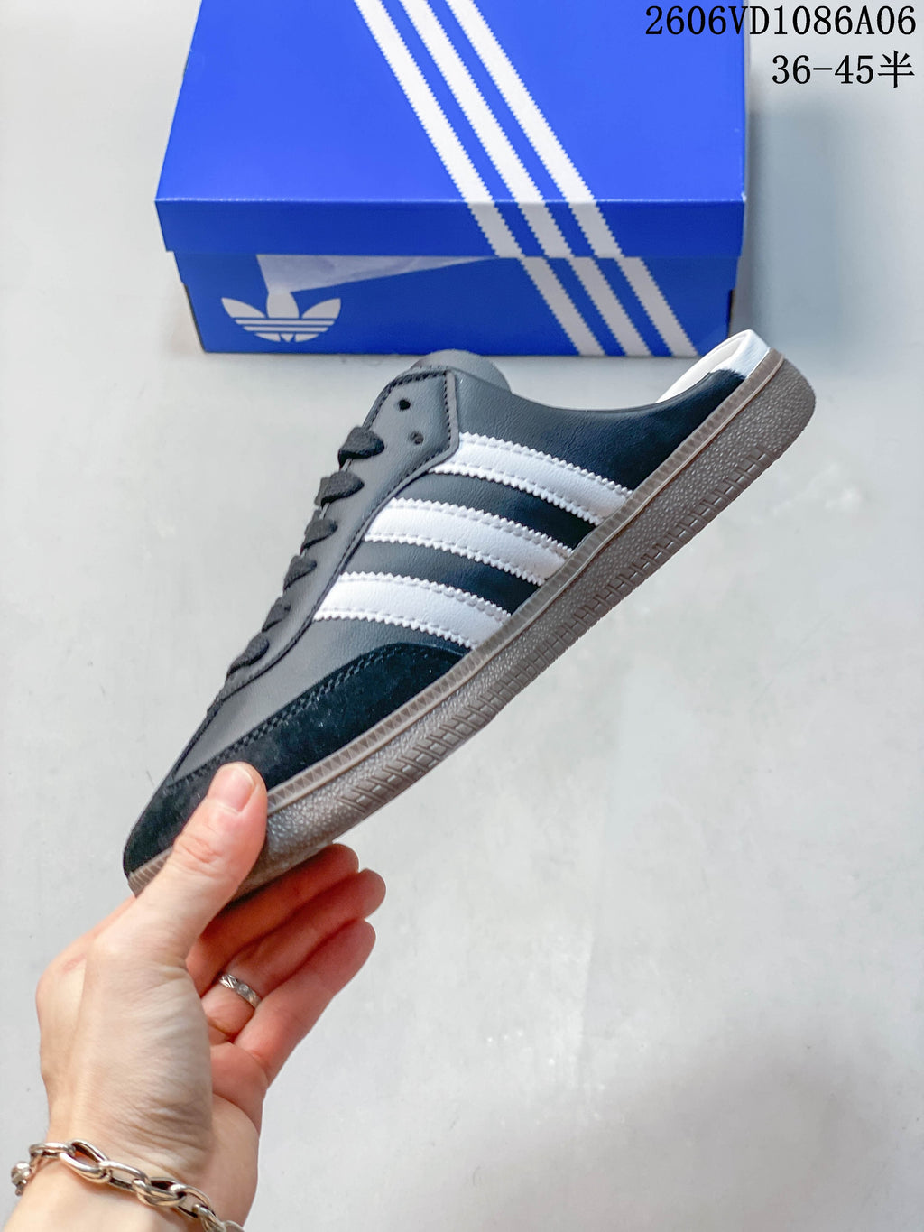Side profile of the dark gray sneaker with white stripes and open heel