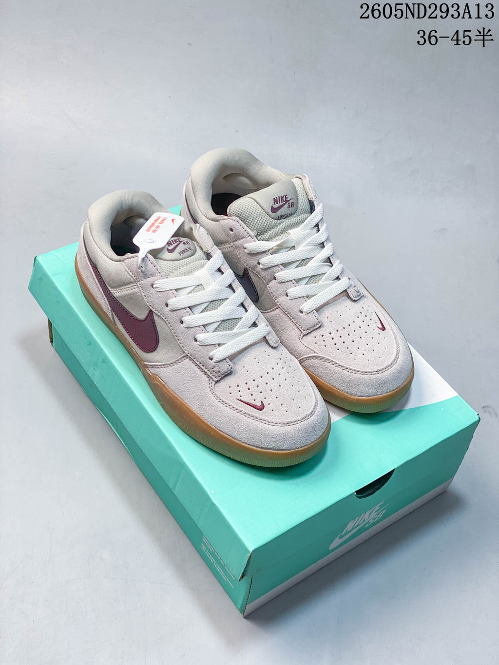 Pair of pale pink and gray Nike SB Force 58 low-top shoes with burgundy accents and gum soles