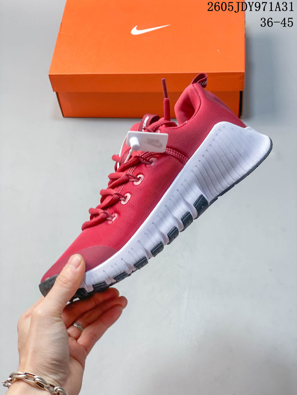 Side view of the red Nike Free Metcon 6 training shoe with a white midsole and dark outsole details