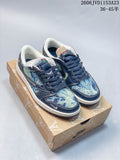 Pair of blue patterned low-top sneakers with dark navy overlays and laces, shown on a branded box