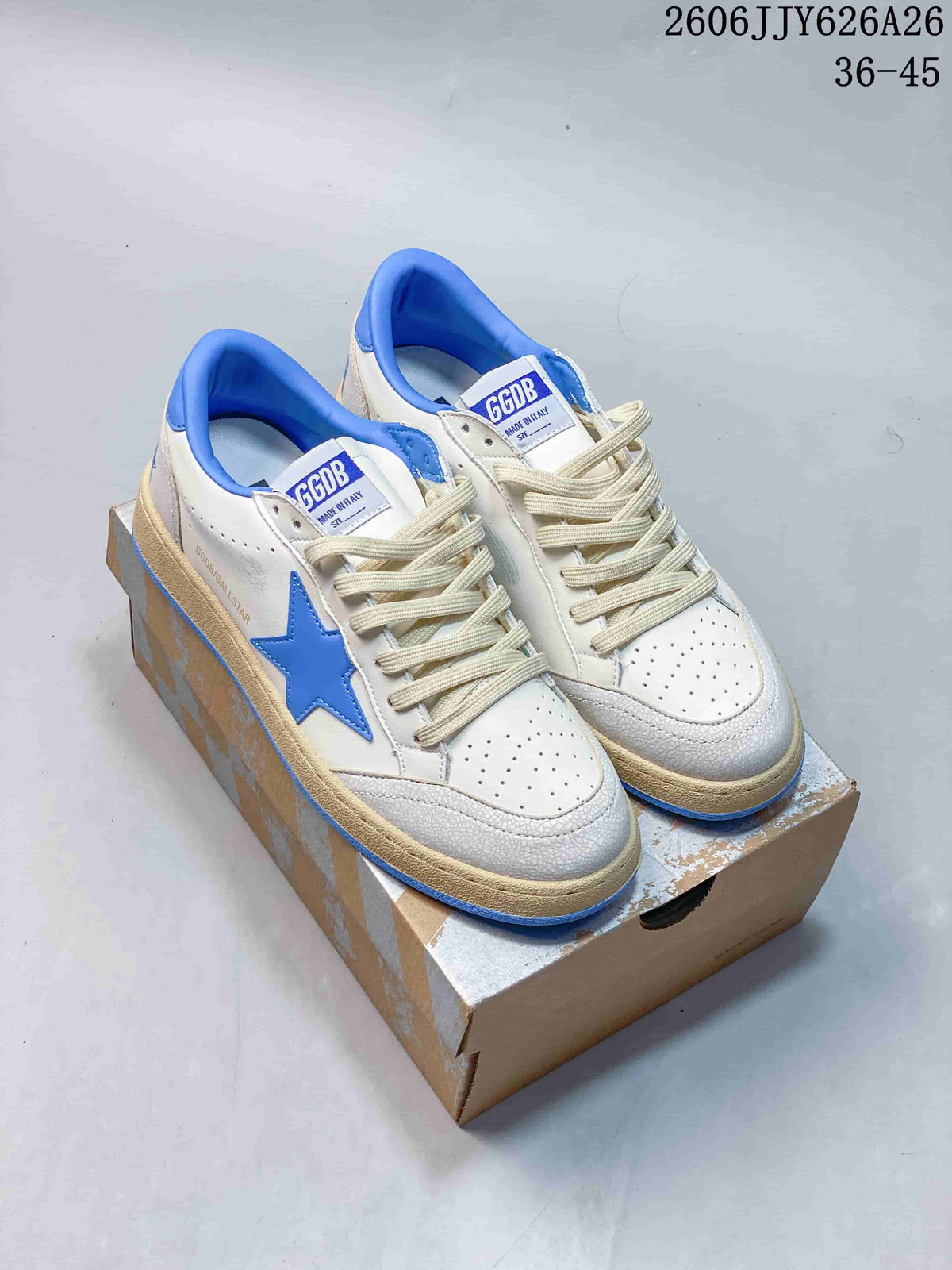Pair of white low-top sneakers with blue star details, blue collar lining, perforated toes, and beige-toned soles.