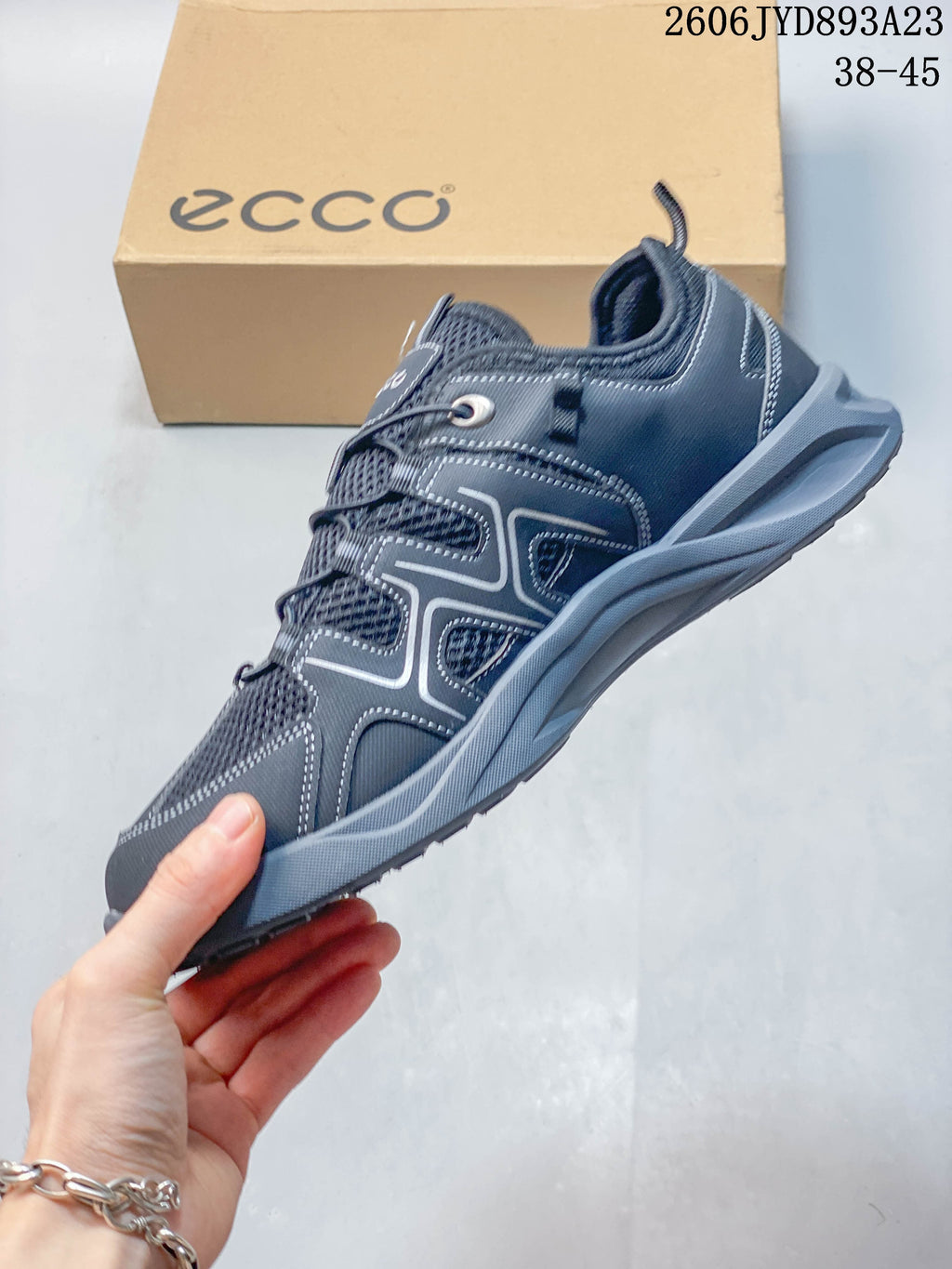 Side view of a gray ECCO low-top shoe with mesh panels and cord lacing
