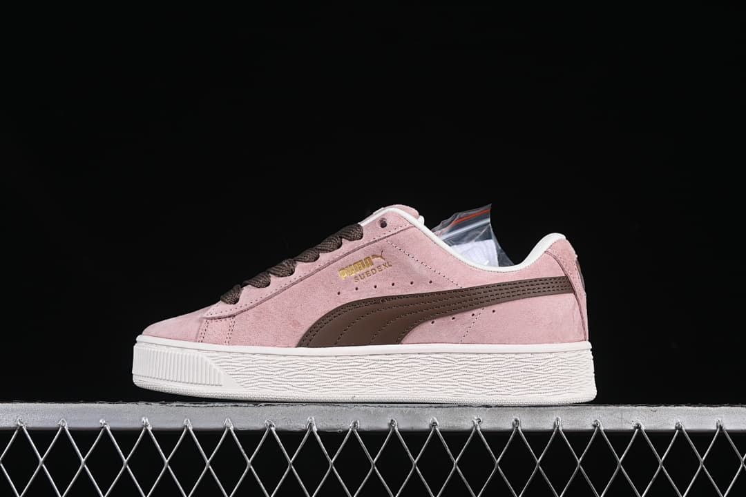Side view of pink Puma Suede XL sneakers with dark brown accents and a white sole.