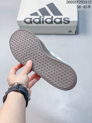 Close view of the patterned gum-colored outsole and adidas shoebox.