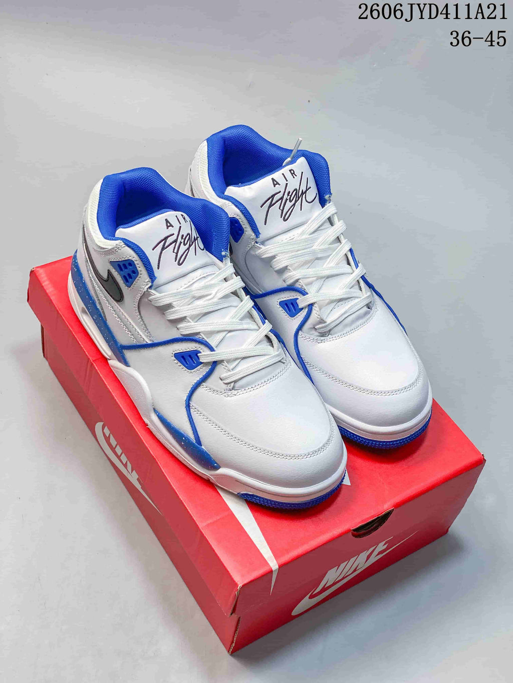 Pair of white Nike Flight Legacy mid-top sneakers with blue accents and white laces