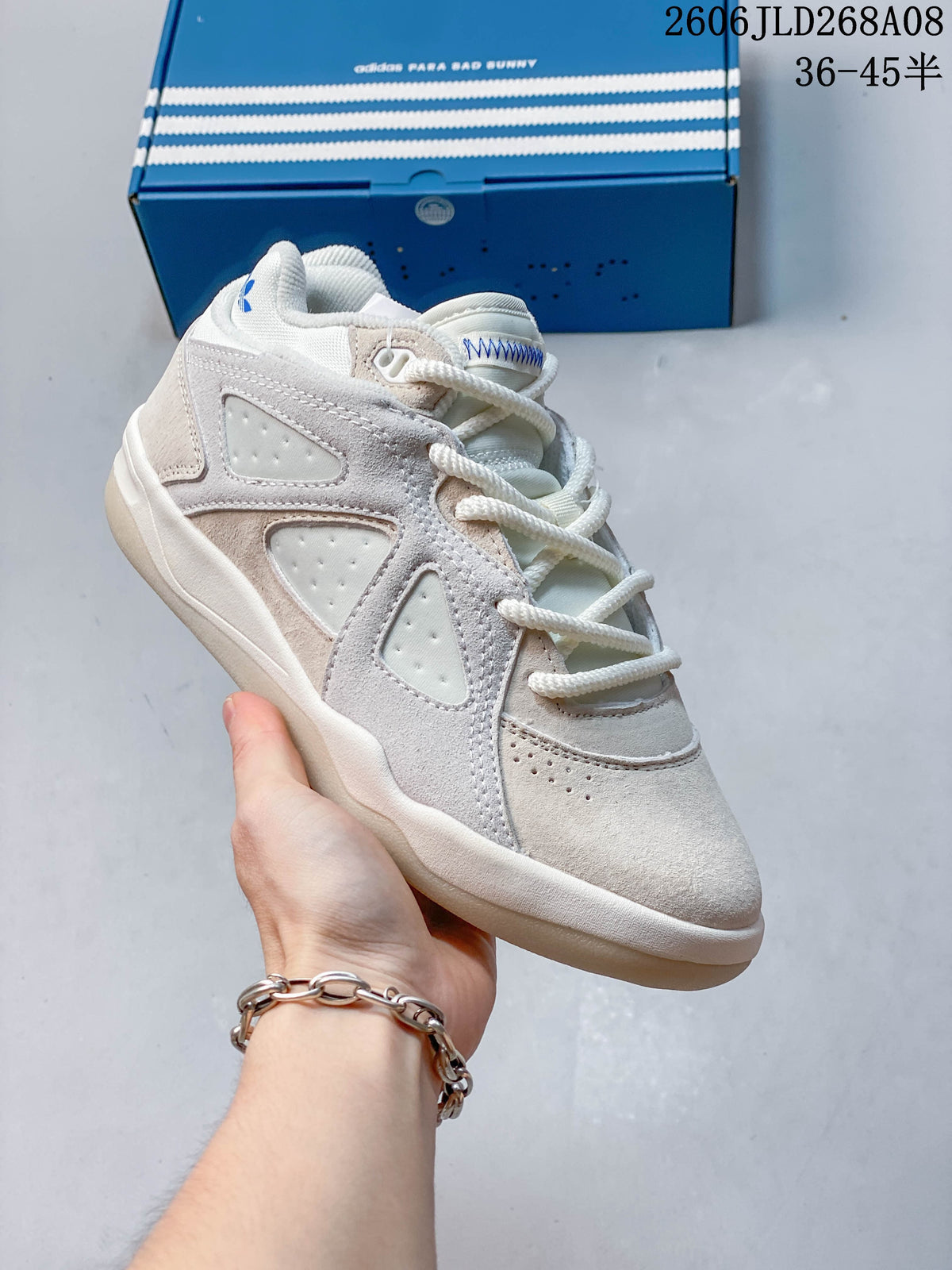 Angled side view of the cream sneaker with blue accents and layered panels