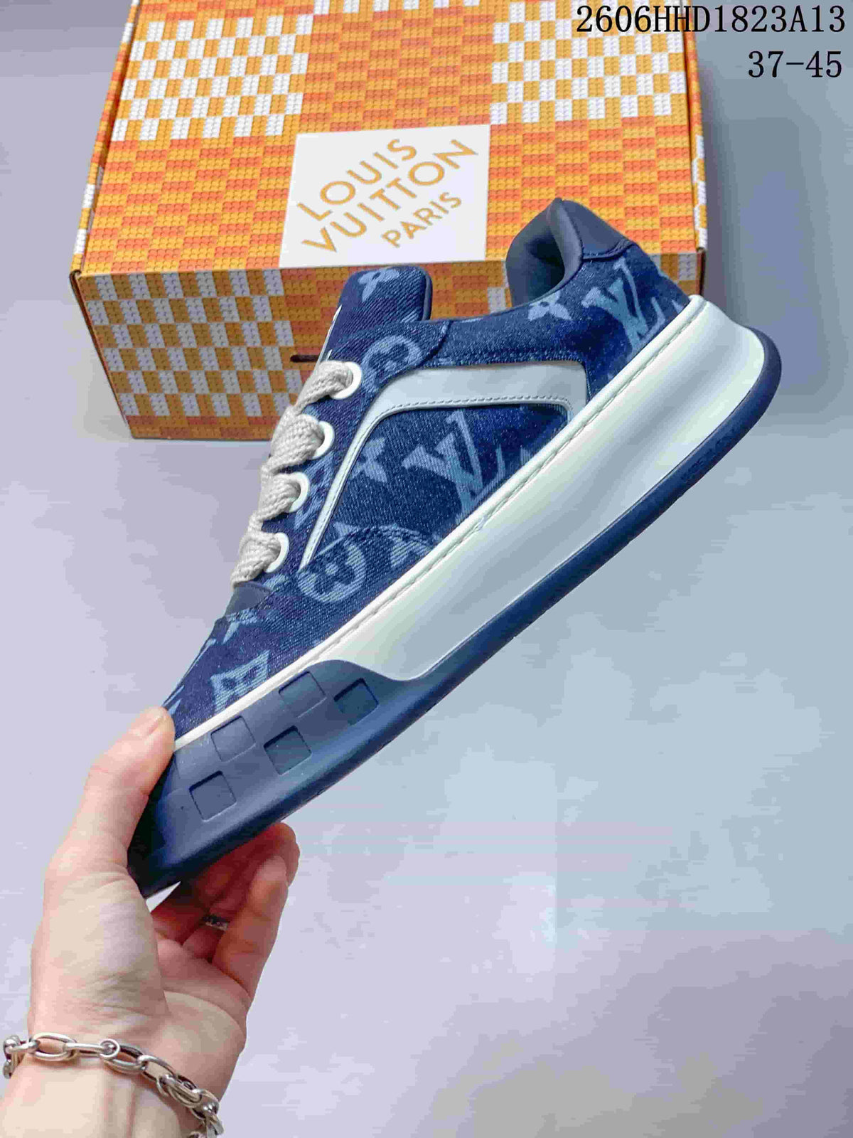 Side view of a blue patterned low-top sneaker with white side trim and a chunky sole.