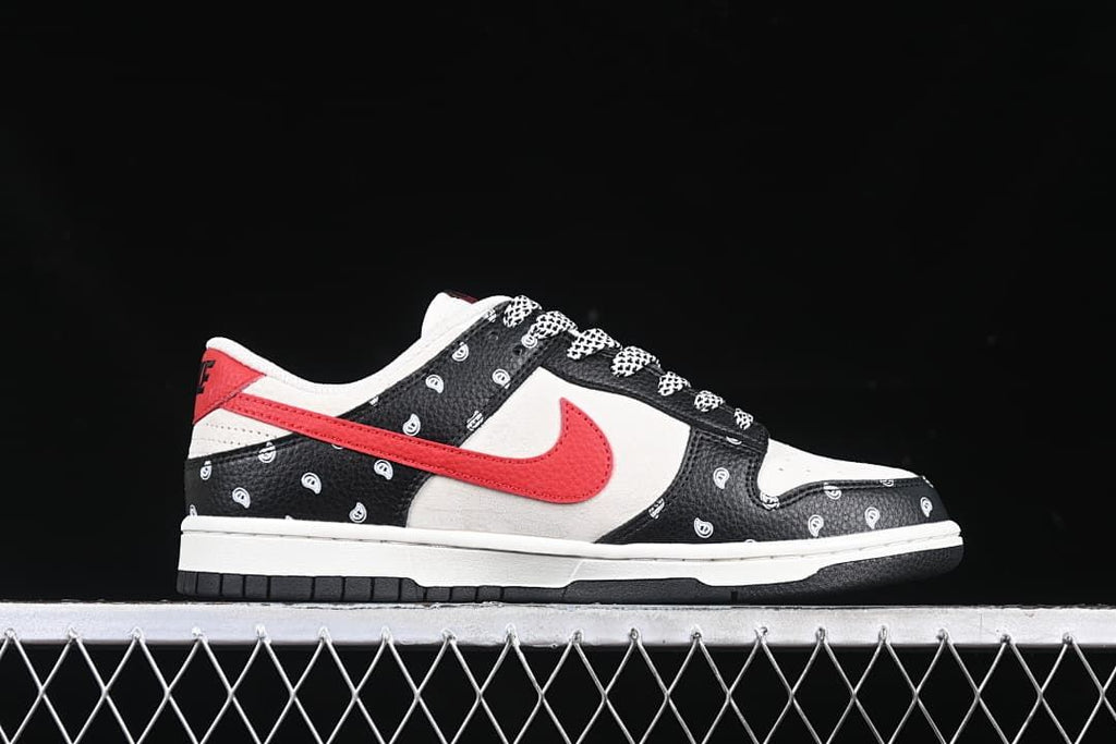 Side profile of a low-top sneaker with a red Swoosh and paisley-patterned black overlays.