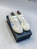 Pair of cream Onitsuka Tiger Mexico 66 Deluxe sneakers with pastel accents, shown on a black shoe box.