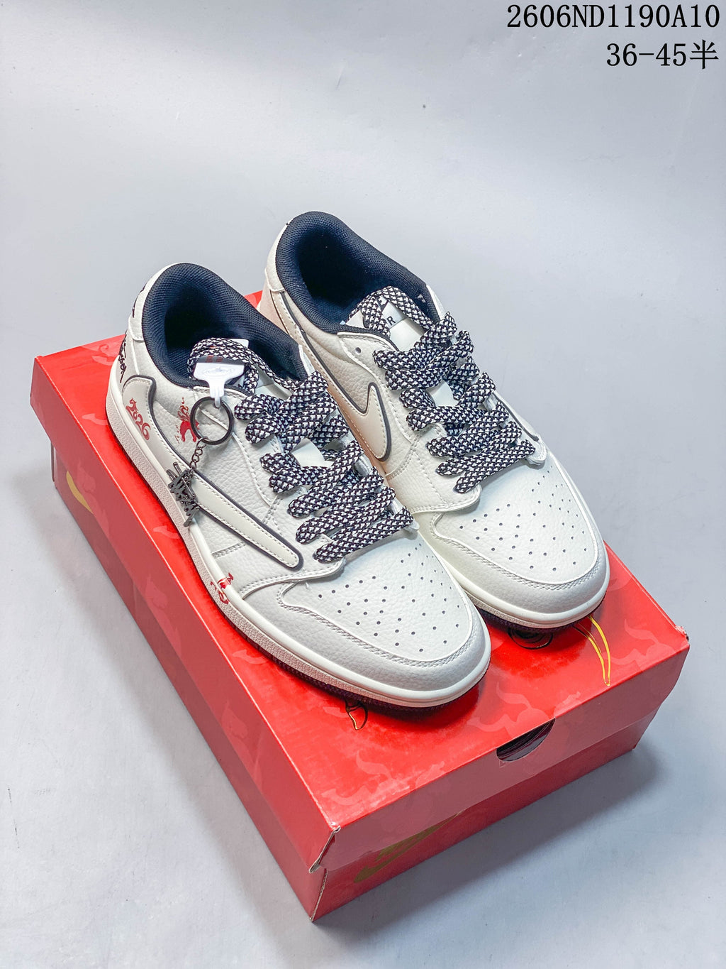 Off-white Air Jordan 1 Low sneakers with dark patterned laces and red horse-themed details, shown on a red box