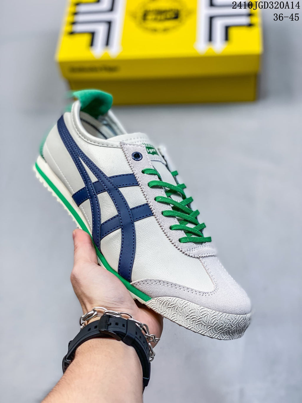 White low-top sneaker with navy side stripes, green laces, and green accents