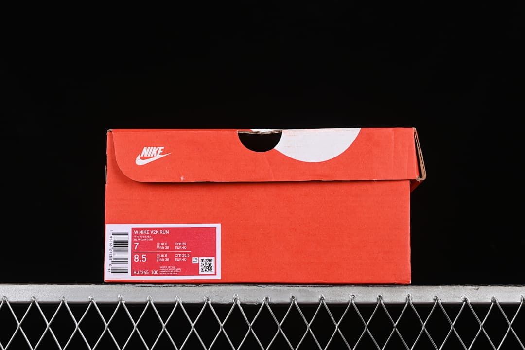 Red shoe box with a product label identifying the W Nike V2K Run and HJ7245-100.