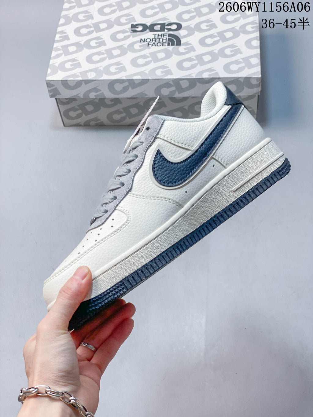 Side view showing the off-white upper and navy side accents of a Nike Air Force 1 '07 Low sneaker.