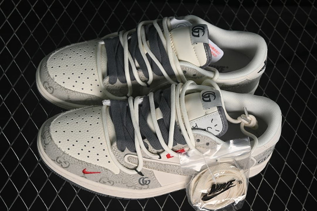 Top view of a pair of light beige and grey patterned low-top sneakers with contrasting laces and an extra lace set