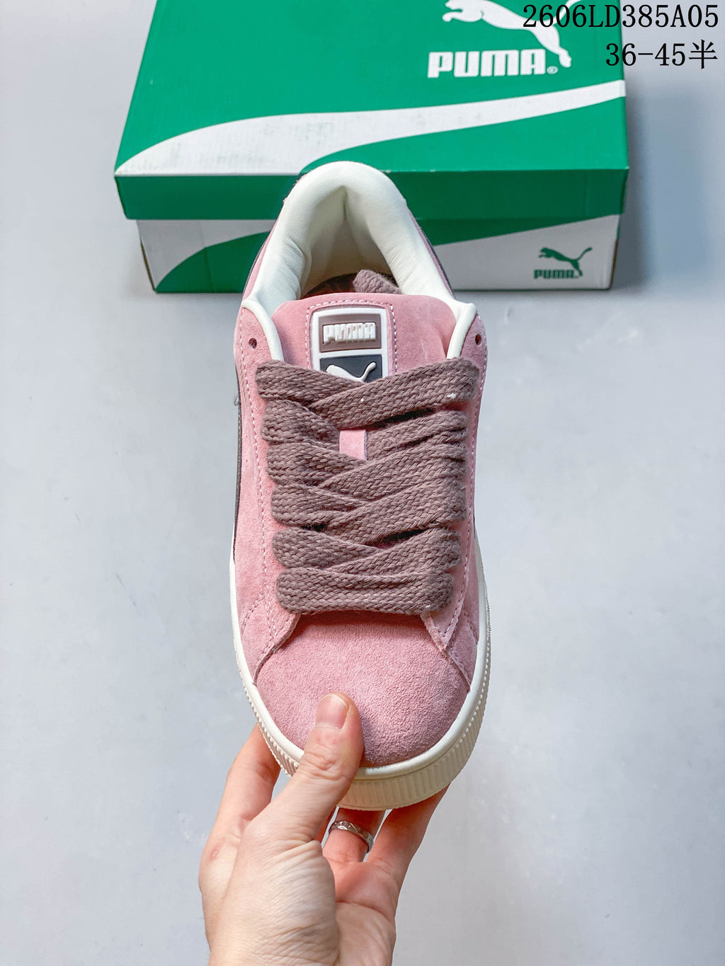 Front view of a pink PUMA sneaker with wide laces and a rounded toe