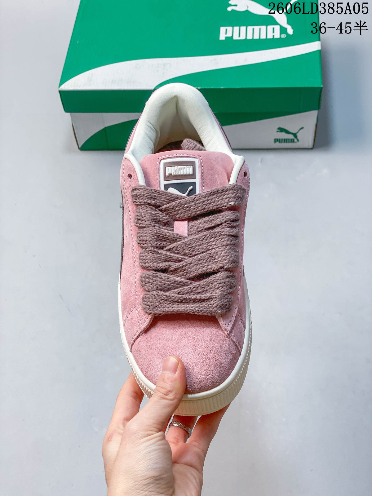 Front view of a pink PUMA sneaker with wide laces and a rounded toe