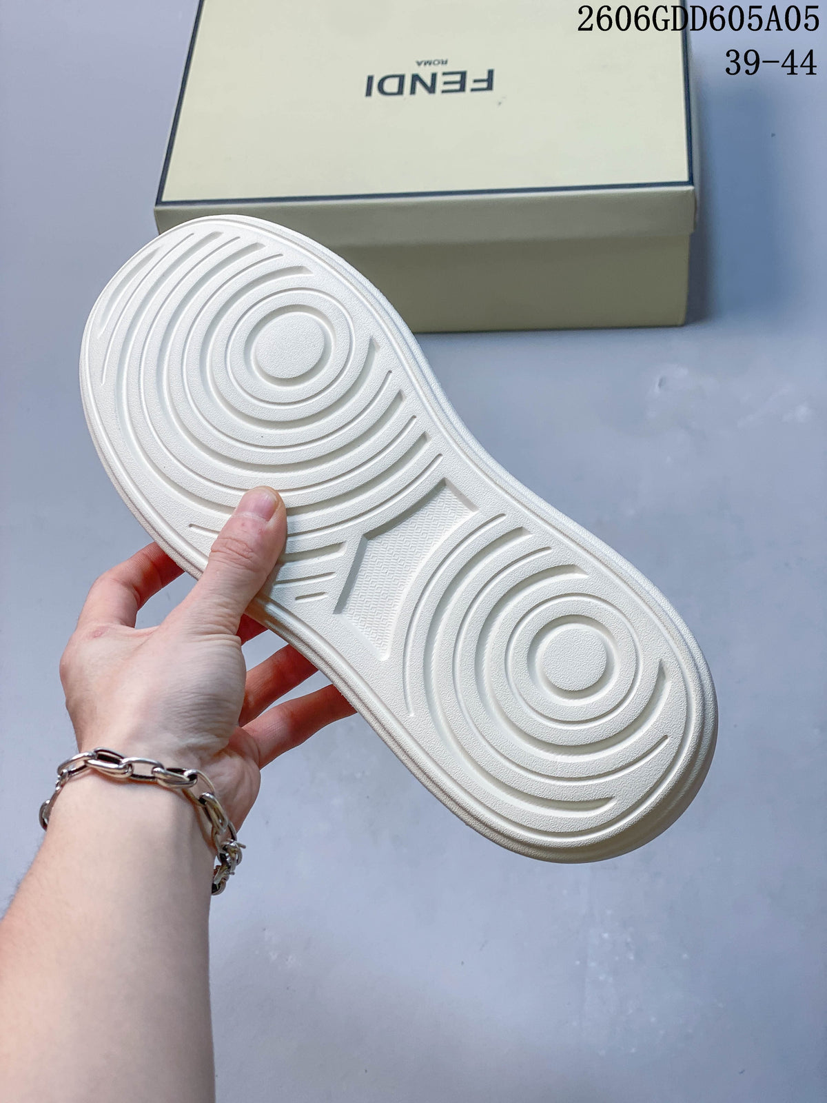 Underside of a light-colored sneaker showing circular tread grooves.