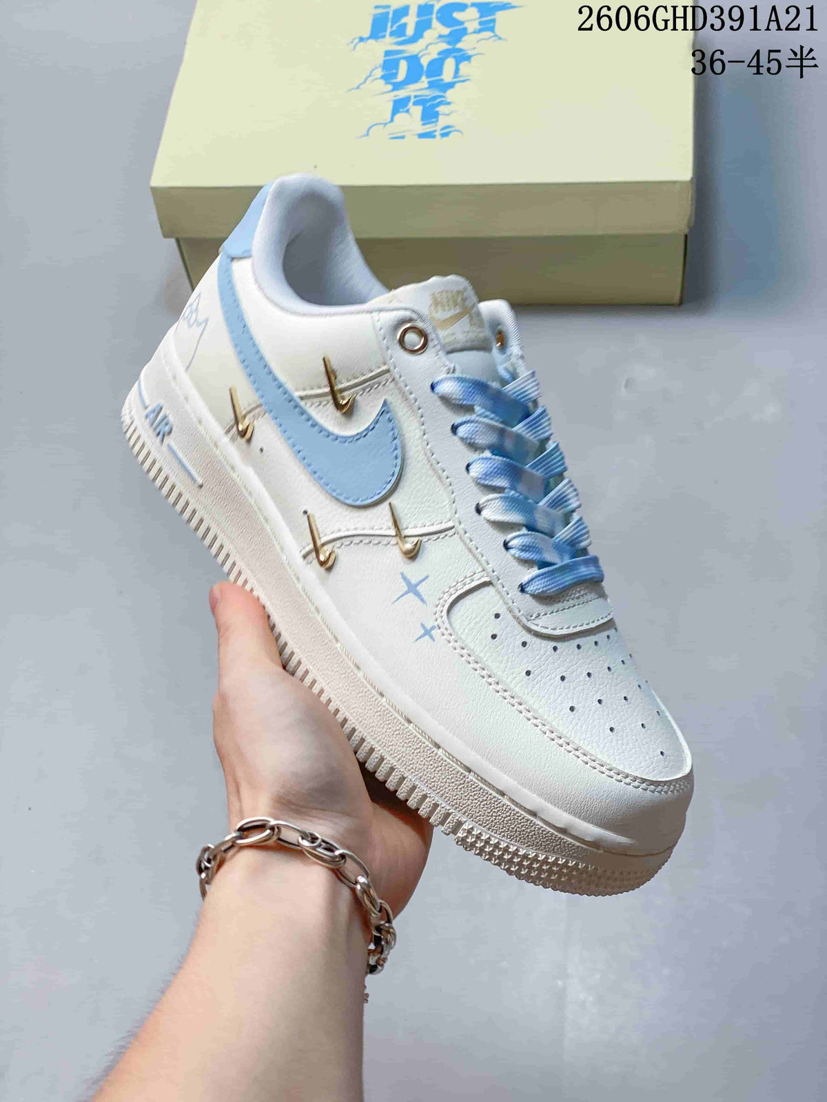 Angled side view of the white sneaker with light blue and gold-tone details